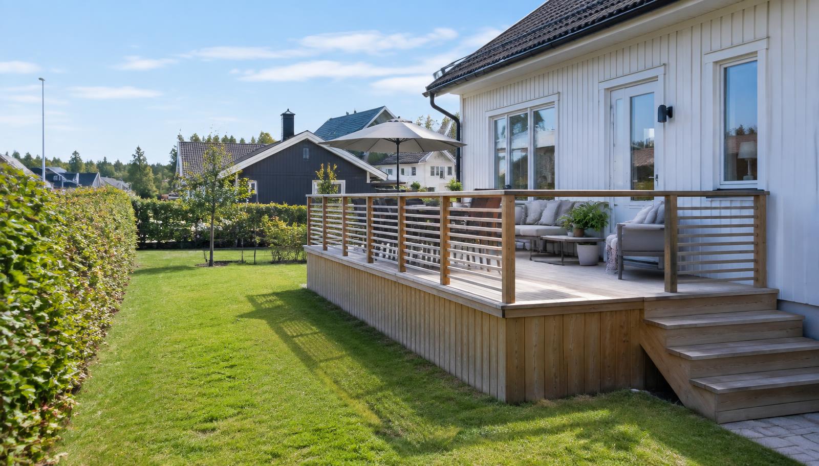 Färdig träaltan med räcke intill en svensk villa